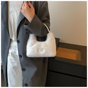Detail of soft white faux fur handbag featuring one every day label and top handle