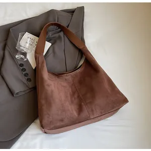 Close-up of deep brown suede hobo bag with textured matte finish and leather strap