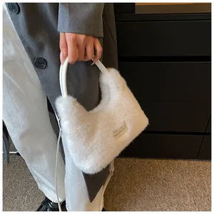 Detail of white faux fur handbag with love every day label and solid handle