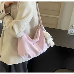 Detailansicht einer rosa Samt-Tote-Bag mit einem niedlichen weißen Teddybären-Anhänger