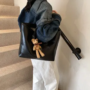 Black large capacity faux leather tote bag with patchwork detail and teddy bear charm