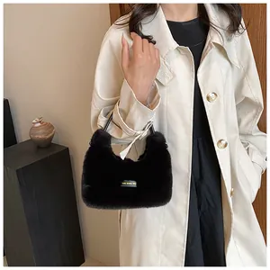 Detail of plush black faux fur handbag with 'love every day' tag and soft texture