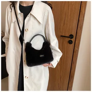 Detail of black faux fur plush handbag with 'love every day' patch on model with trench coat