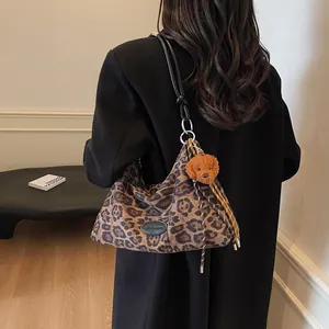 Fashionable leopard print tote bag with plush puppy charm and black leather shoulder strap
