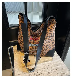 Detailed view of leopard print tote bag with cartoon dog prints on a marble surface