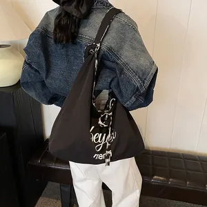 Minimalist black canvas tote bag with letter print and patterned floral strap with bow