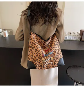 Detail of leopard print tote bag with dachshund print worn over the shoulder