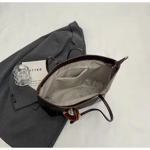 Vue détaillée de l'intérieur du grand sac cabas marron avec doublure et poche zippée