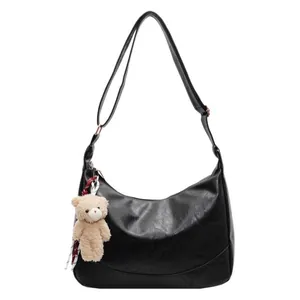 Classic black leather hobo bag with adjustable strap and cute plush bear charm decoration