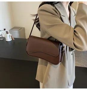 Close-up of brown litchi leather bag featuring wavy flap edge and gold hardware detail