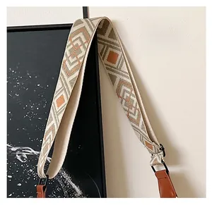 Gros plan sur une large bandoulière jacquard bohème avec motifs géométriques et cuir