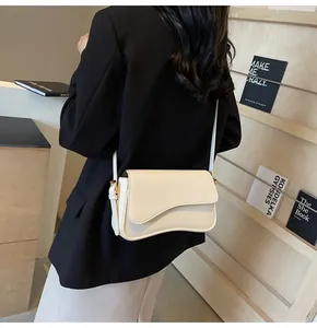 Close-up of cream lychee texture crossbody bag with wave-cut flap on a female model