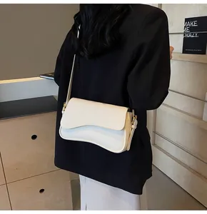 Close-up of cream lychee texture crossbody bag with asymmetrical flap and gold hardware