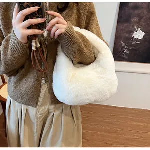 Close-up of white plush handbag featuring soft faux fur texture and a crescent shape