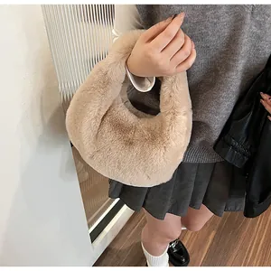 Detailed close-up of a plush beige faux fur handbag featuring a soft rounded handle