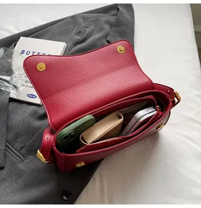 Macro view of red lychee leather handbag interior with spacious pockets and compartments