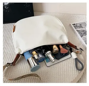 Vue interne montrant la grande capacité du sac blanc avec bandoulière tissée