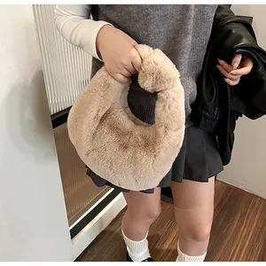 Detail of soft beige plush handbag with knot handle design and fluffy faux fur texture