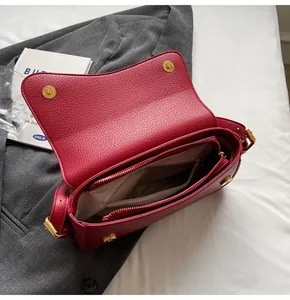 Interior view of wine red crossbody bag showing main compartment and zippered pockets