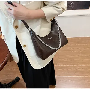 Detail of dark brown hobo bag with crackle texture and silver chain strap details