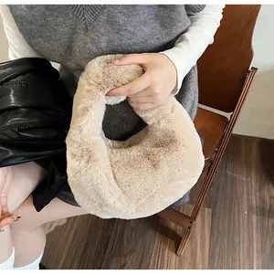 Close-up of a soft beige faux fur handbag held by a model for a cozy autumn winter look