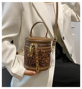 Close-up of leopard print bucket bag featuring premium leather trim and gold hardware details