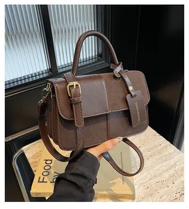 Vista detallada del bolso bandolera de cuero marrón oscuro y textura de gamuza suave