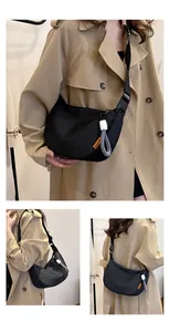 Détail du sac bandoulière croissant noir montrant le tissu nylon et le pendentif mode