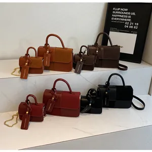 Detalle de bolsos cuadrados en cuatro colores con mezcla de cuero liso y ante elegante