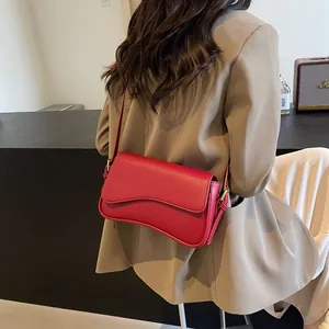 Chic red lychee pattern crossbody bag with wavy flap and adjustable gold strap hardware