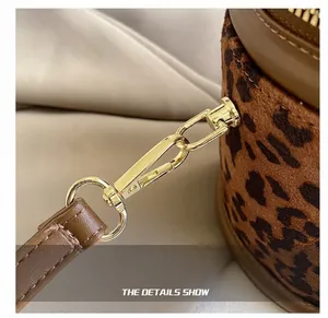 Detail of leopard print bucket bag featuring gold metal hook and brown leather strap