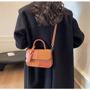 Detalle de bolso vintage marrón con texturas de cuero liso y gamuza elegante