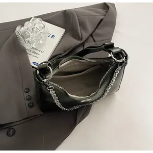 Detail shot of green leather bag interior with zipper pocket and silver chain strap