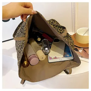 Vue de dessus du sac léopard montrant l'intérieur spacieux avec tablette et cosmétiques