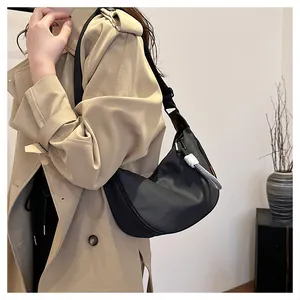 Détail du sac hobo en nylon noir avec nœud de corde tressé blanc en contraste