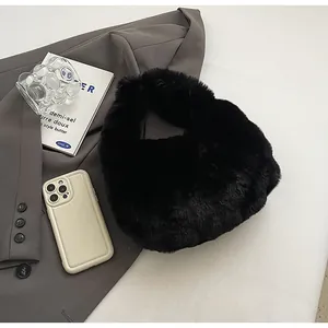 Close-up of black faux fur handbag with soft texture on a dark grey blazer outfit