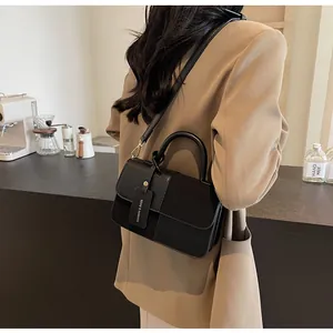 Detalle de un elegante bolso bandolera negro con texturas mixtas en interior moderno