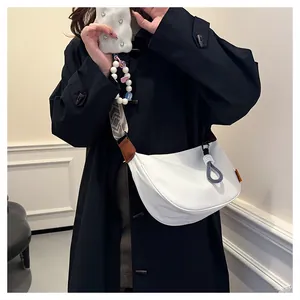 Sac hobo blanc avec bandoulière tissée géométrique amovible sur un manteau noir