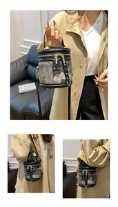 Close-up of geometric grey and black bucket bag with gold zipper and ring handle