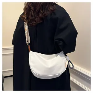 Détail du sac bandoulière blanc demi-lune avec large sangle aux motifs géométriques