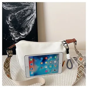 Vue détaillée du sac beige avec bandoulière géométrique et iPad pour comparer la taille