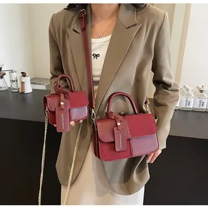 Detalle de bolsos de piel patchwork burdeos con cadena metálica y etiqueta de moda lujo