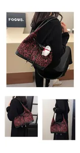 Detail of leopard print tote bag with wine red accents and snowman plush charm