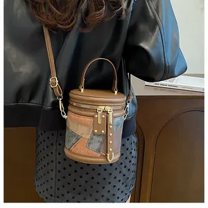 Chic multi-color leather bucket bag shown on a model in a warm urban setting