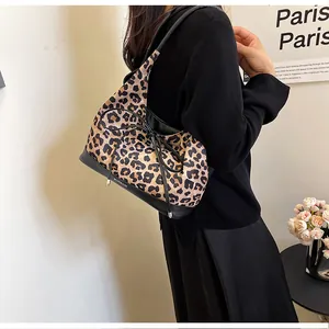 Detail view of leopard print tote bag with black leather trim and bow decoration