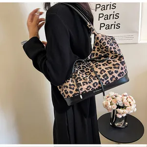 Detail of leopard print tote bag with black leather straps and a delicate bow knot