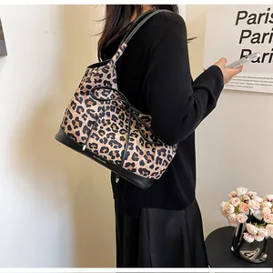 Detail of leopard print tote bag featuring a decorative bow and reinforced leather base