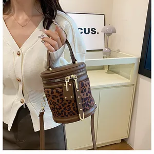 Detail view of leopard print bucket bag with golden hardware and detachable strap