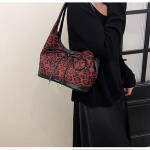Detail of leopard print tote bag featuring black PU straps and red animal pattern