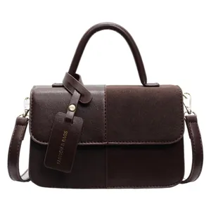 Bolso bandolera marrón de cuero con costuras de textura mixta y asa dorada